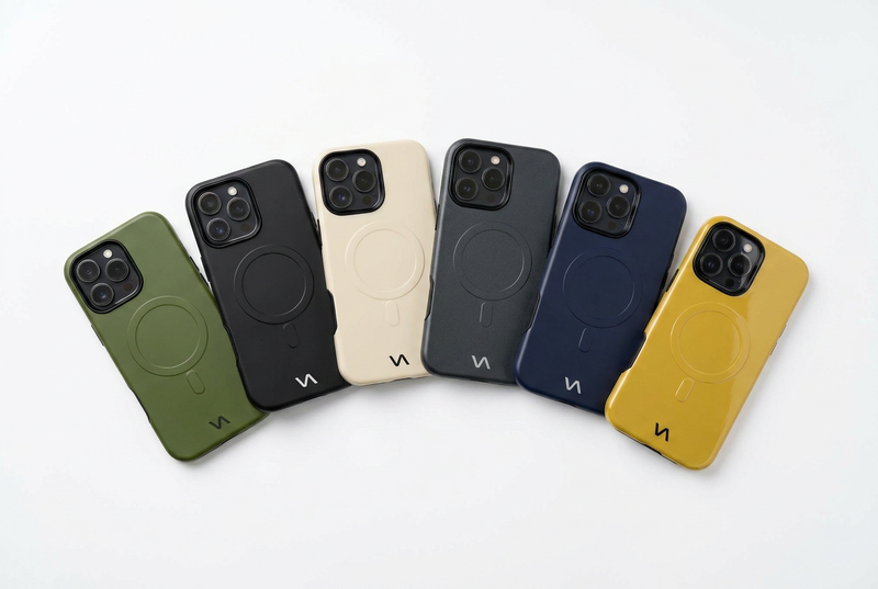Olive Green, Onyx Black, Ivory Silk, Graphite, Midnight Blue, and Gold slim MagSafe iPhone cases fanned out on a white surface — VitaAurea iPhone Cases Collection.