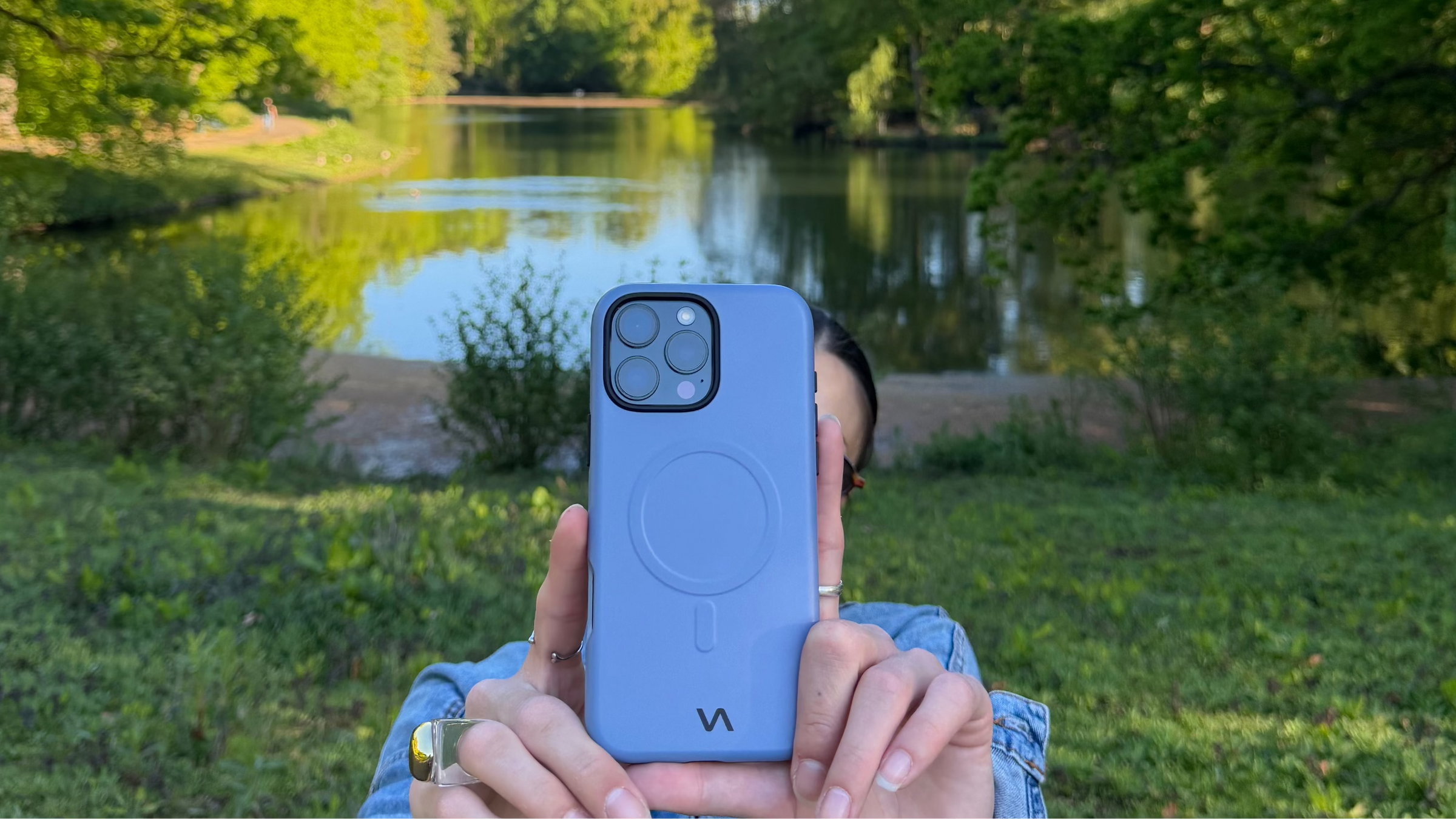 Steel Mist VitaAurea iPhone case held by a girl in a park.